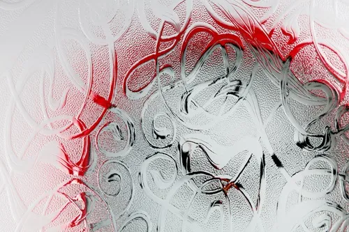 A red wall clock completely obscured by high-distortion patterned glass.