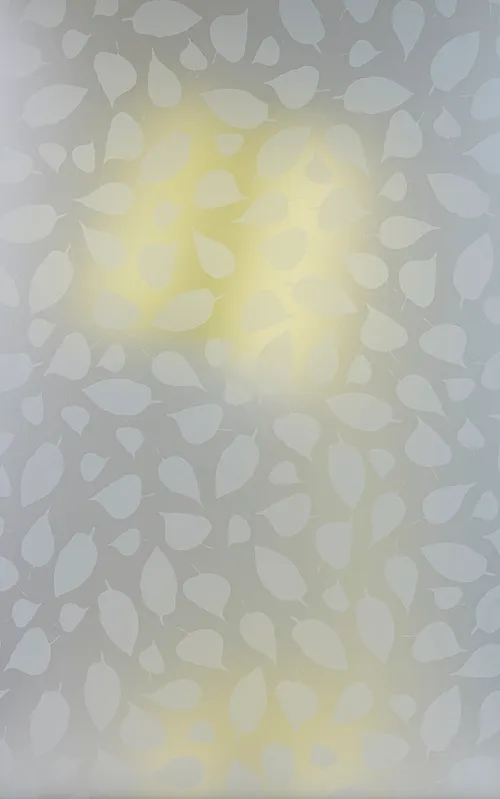 A yellow desk lamp obscured behind a heavily frosted glass panel with a leaf pattern.