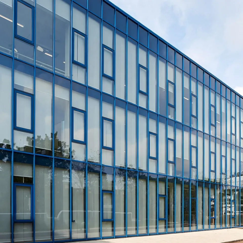 Modern glass office building with blue window frames.